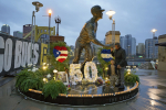 Roberto Clemente Jr., right, son of Pittsburgh Pirates' Roberto Clemente, and his son Robert Clemente III visit a statue of his father outside PNC Park in Pittsburgh on Saturday, Dec. 31, 2022, during a commemoration of the 50th anniversary of the plane crash that took the life of Clemente. Clemente died at the age of 38, when the plane carrying relief supplies to earthquake victims in Nicaragua crashed off the coast of Puerto Rico with Clemente on board. (AP Photo/Gene J. Puskar)