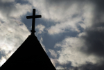 The cross on the steeple of St. Francis Xavier Catholic Church is undamaged in Henryville, Ind., Saturday, March 3, 2012. The church, in the path of the storm, suffered roof damage but with hold services in the church on Sunday. Three people were killed in Southern Indiana by Tornados on Friday. (AP Photo/Michael Conroy)