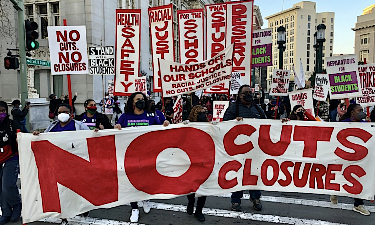 Above, an Oakland school closure protest as recorded by the California Teachers Association. Unions argue that closures pose unfair labor practices. And racial justice advocates call the issue a matter of equality rather than wasteful spending. Julian Peeples / California Teachers Association