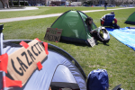 A Massachusetts Institute of Technology student reads while seated in a tent, Monday, April 22, 2024, at an encampment of tents on the MIT campus, in Cambridge, Mass. Students at MIT set up the encampment to protest what they said was MIT's failure to call for an immediate ceasefire in Gaza and to cut ties to Israel's military. (AP Photo/Steven Senne)