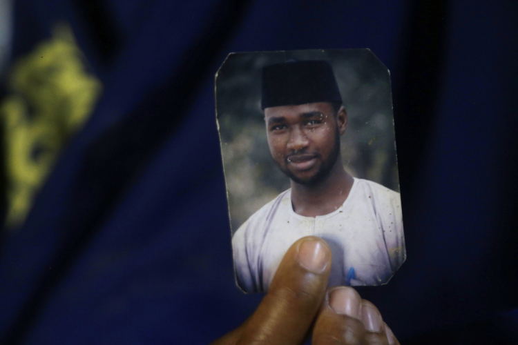 Mubarak Bala's wife holds a picture of him after he was sentenced to prison time for blasphemy. AP