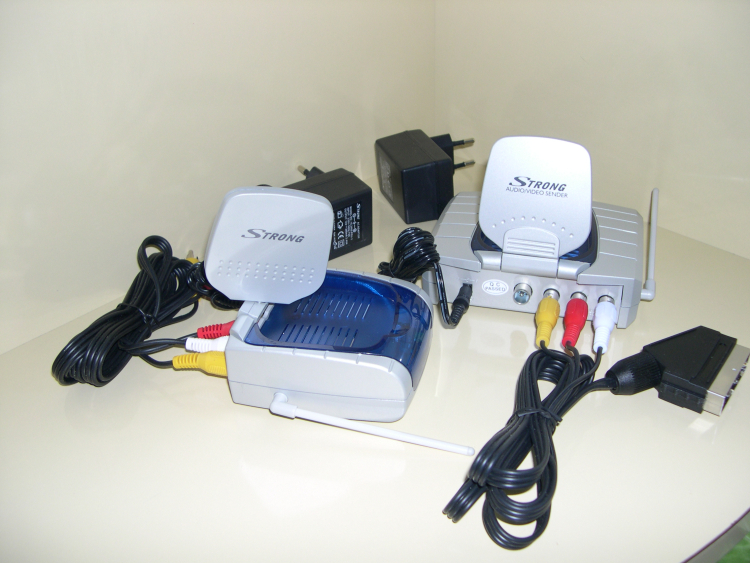 Kit transmetteur sans-fil 2.4 Ghz pour distribuer la TNT ou le SAT, etc. au domicile ou pour transporter les images d'une caméra déportée à vue, max 1 km.. Sur la partie récepteur (à droite) on note, sur ce produit plutôt haut de gamme, la sortie modulée dans le canal traditionnel UHF  "G" PAL, c 36 ou 591 MHz,  pour les téléviseurs sans péritel (scart)ou déjà occupée.
Puissance: 10 dBm. ( @ 2450 Mhz 75 Ohms)
Sélection:  4 canaux de 18 Mhz au pas de 21 Mhz (départ 2410 Mhz)
antenne 2.4 GHz : directive patch polarisation linéaire V.( transmetteur sous attitude habituelle ) Antenne omni pour le 433 Mhz.
contraste TX: réglable, normal ou fortLes canaux 1 et 2 peuvent être "retenus" par les radioamateurs.La partie TX est conforme aux attentes normales, en revanche le récepteur n'est pas très sensible. L'ensemble convient pour un usage habituel.( 79 ? ) 

Autres transmetteurs testés, gamme VS Thomson, corrects
